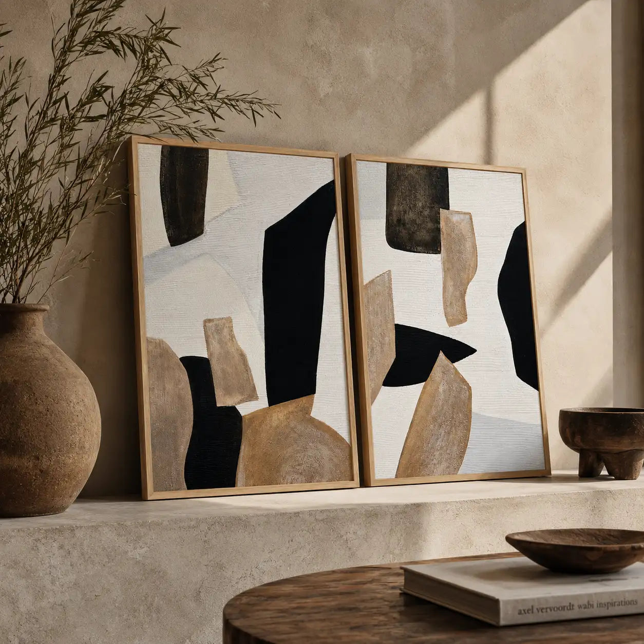 Dos cuadros abstractos en tonos tierra colgados sobre aparador de madera en salón moderno